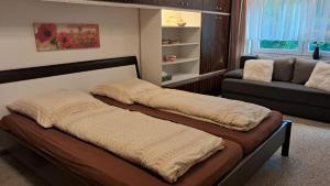 two beds in a living room with a couch at Kurpark Domizil in Altenau