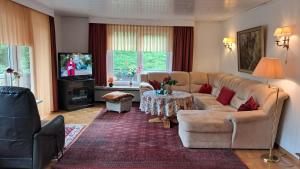 a living room with a couch and a table at Kurpark Domizil in Altenau