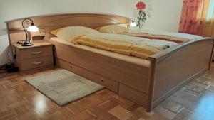 a bedroom with a large wooden bed with a night stand at Kurpark Domizil in Altenau