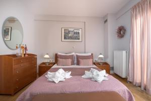 a bedroom with a large bed with white towels on it at Villa Anavil - Boutique Coastal Retreat in Varkiza in Vari
