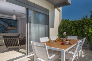 a dining table and chairs on a patio at Villa Anavil - Boutique Coastal Retreat in Varkiza in Vari