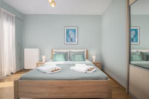 a bedroom with a large bed with two towels on it at Villa Anavil - Boutique Coastal Retreat in Varkiza in Vari