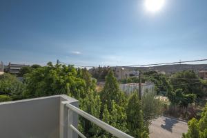 a balcony with a view of trees and buildings at Villa Anavil - Boutique Coastal Retreat in Varkiza in Vari