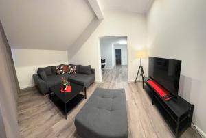 a living room with a couch and a flat screen tv at Apartment A&A in Niederdorf
