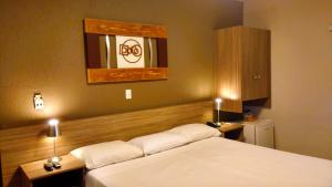 Una habitación de hotel con dos camas y un espejo. en Hotel Imperador, en Santos