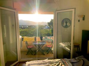 a room with a balcony with a table and a view at SAINT FLORENT studio terrasse 2 à 3 personnes calme avec piscine au sel in Saint-Florent +44 photos