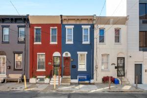 a row of colorful houses on a street at Bright Corner Flat Near Transit And Trails in Philadelphia