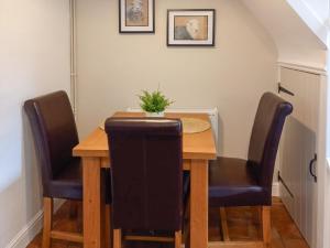 een eettafel met 2 stoelen en een houten tafel bij 1 Tower Cottage in Portinscale