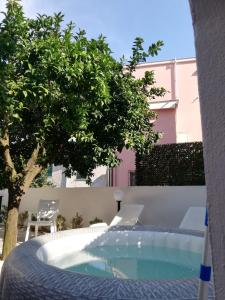 a swimming pool with a table and chairs and a tree at Casa vacanze Amalfitan Coast in Vietri sul Mare