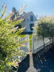 a white picket fence in front of a house at Dom wakacyjny z podgrzewanym basenem w tarasie i jacuzzi pod gwiazdami, Studnica, Ińsko, "THerapeutica"  +27 photos
