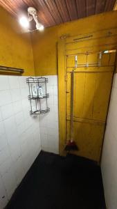 a bathroom with a yellow door and a white tile wall at Cop30 in Belém +17 photos