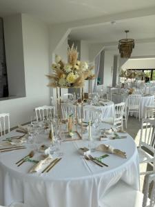a dining room with white tables and white chairs at Domaine du Haut-Koenigsbourg in Orschwiller