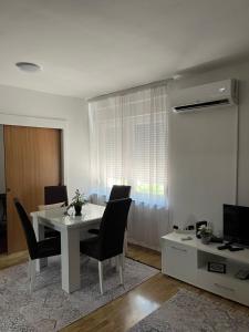 a dining room with a white table and chairs at Apartman Reyan in Jajce