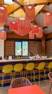 a restaurant with colorful chairs and chandeliers at Camping du Pas Del Fang in Sainte-Marie-la-Mer