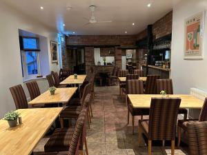 a dining room with wooden tables and chairs at The Boughton Peterchurch - Pub Grub & Bed in Peterchurch