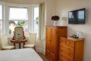 a bedroom with a bed and a dresser with a mirror at The Boughton Peterchurch - Pub Grub & Bed in Peterchurch