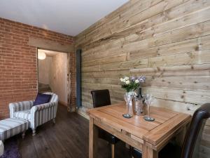 a dining room with a wooden wall at The Coach House - Ukc2365 in Watton