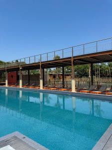 a large swimming pool with chairs and a bridge at Camping du Pas Del Fang in Sainte-Marie-la-Mer