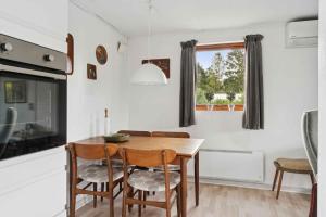 Un comedor con mesa y sillas de madera. en Cozy Cottage Near Beach And Nature, en Vesterby 6 fotos más