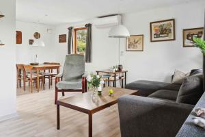 una sala de estar con un sofá y una mesa en Cozy Cottage Near Beach And Nature, en Vesterby