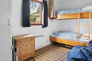 Un dormitorio con dos literas y una cómoda. en Cozy Cottage Near Beach And Nature, en Vesterby