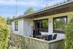 Un patio con sillas y una mesa en una casa. en Cozy Cottage Near Beach And Nature, en Vesterby