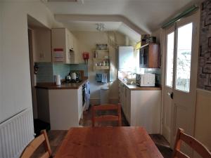 a small kitchen with a wooden table and chairs at Oswin Cottge in Alnwick +9 photos