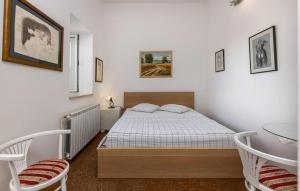 a bedroom with a bed and two chairs and a table at 1 Bedroom Awesome Apartment In Kampor in Kampor