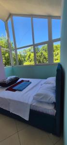 a bed in a room with windows at Bujtina Trofta Jone in Shëngjin