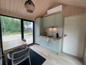 ein Zimmer mit einer Küche mit Tisch und Fenster in der Unterkunft Järvemaja in Kaisma