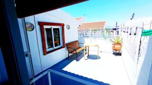 a patio with a chair and a table on a building at Red House in Alhaurín el Grande
