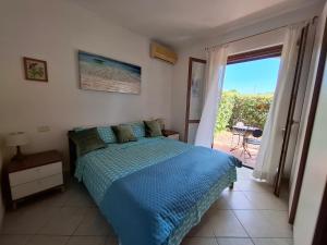 モンテメラノにあるAppartamento tra il mare e le Terme di Saturniaのベッドとガラスの引き戸のある寝室