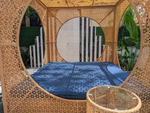 a bed in a wicker structure with a mirror at Villa Candolim in Candolim