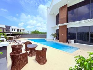 AjaLuxurious 5BR Villa with Private Pool, Lekki Lagos的一个带椅子的户外庭院和一个游泳池