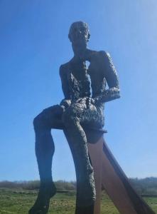a statue of a man sitting on a ladder at Ocean Edge 13 in Heysham