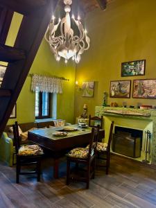 a dining room with a table and chairs and a chandelier at Daphne Retreat in Kernitsa +21 photos