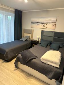 a bedroom with two beds and a window at Villa Na Fali in Grzybowo