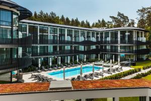 un grande edificio con piscina e sedie di Stegna Deluxe Amber Apartments a Stegna