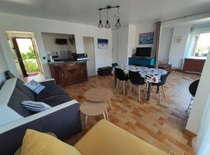 a living room with a couch and a table and chairs at Appartement Salines 46m2 in Carnac