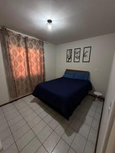 a bedroom with a blue bed and curtains at Casa da Família Tonial in Gramado