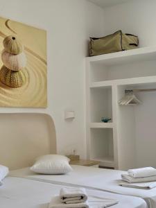 a bedroom with a white bed with aroll at Aegeo Inn in Antiparos