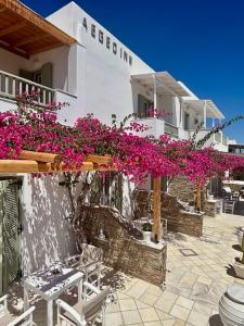 a building with pink flowers on the side of it at Aegeo Inn in Antiparos