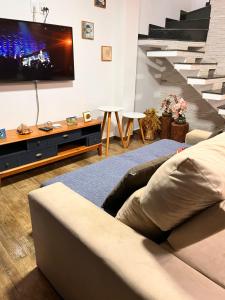 ein Wohnzimmer mit Couch und Flachbildfernseher in der Unterkunft A casa azul in Paraty