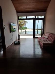 ein Wohnzimmer mit Couch und Blick aufs Meer in der Unterkunft Casa na Barra do Una, à beira do Rio Una e frente a Praia in São Sebastião + 28 Fotos