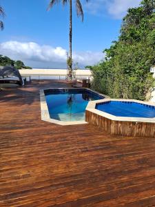 einen Pool auf einer Holzterrasse in der Unterkunft Casa na Barra do Una, à beira do Rio Una e frente a Praia in São Sebastião