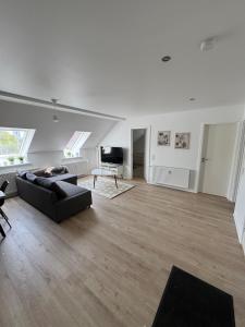 a living room with a black couch and a television at New Exclusive 5 bedroom house for 8 persons - 155m2 in Marslev +10 photos