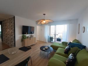a living room with a green couch and a table at le contemporain in Bastia