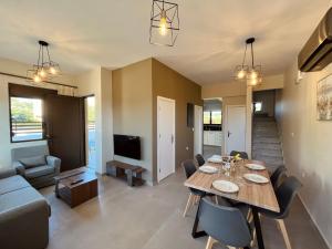 comedor y sala de estar con mesa y sofá en Villa Greige, en Ixia