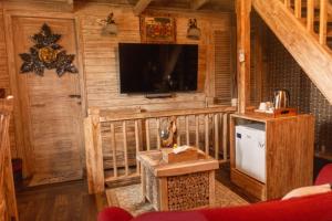 a living room with a television in a cabin at Wisnu Lumbung Uluwatu in Uluwatu