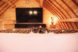 a room with a bed with a television and a table at Wisnu Lumbung Uluwatu in Uluwatu